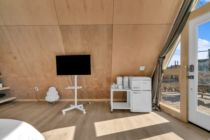 Bedroom with access to outside, wooden walls, and light wood finished floors