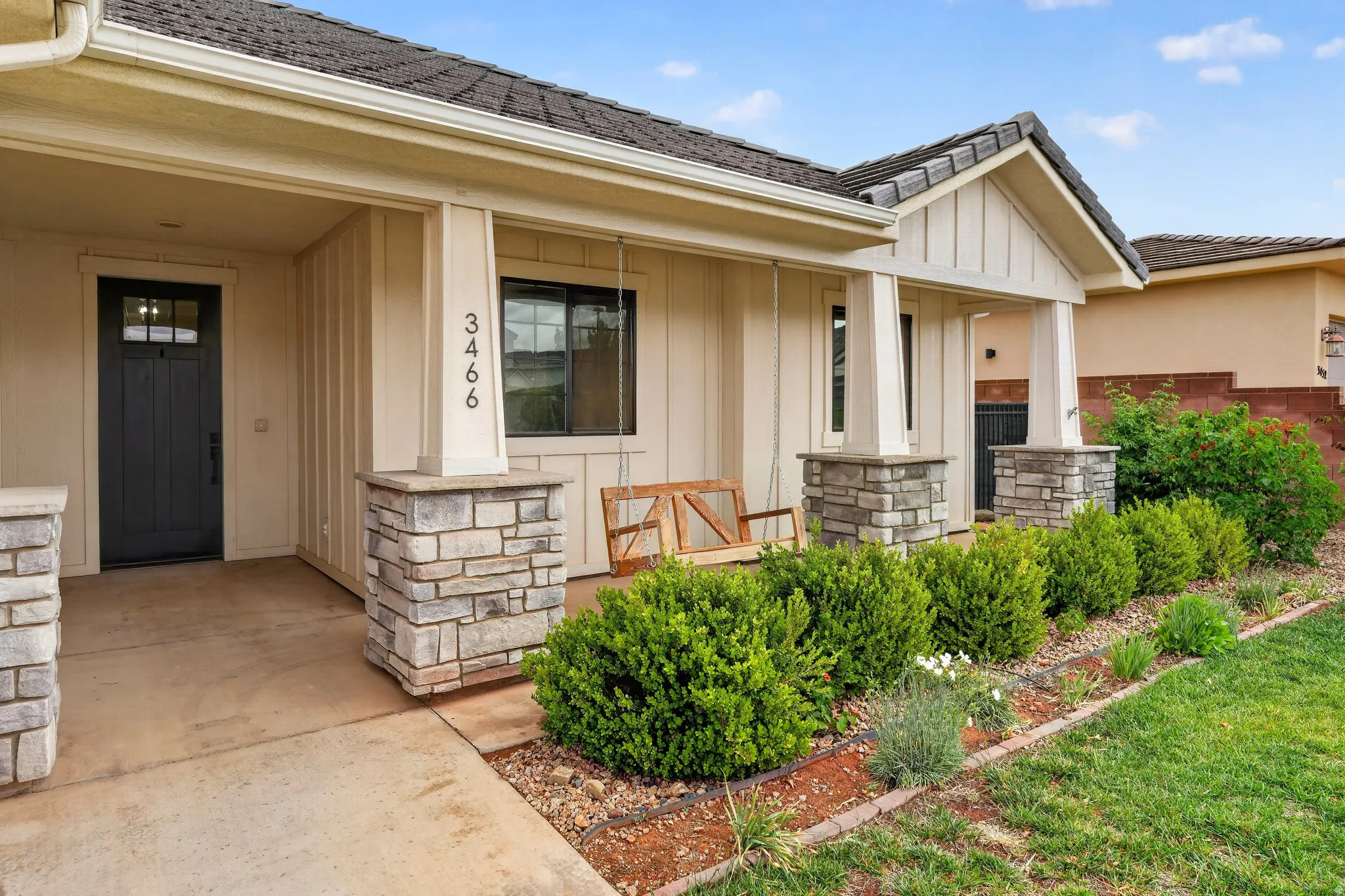 View of exterior entry featuring board and batten siding, covered porch, and stone siding