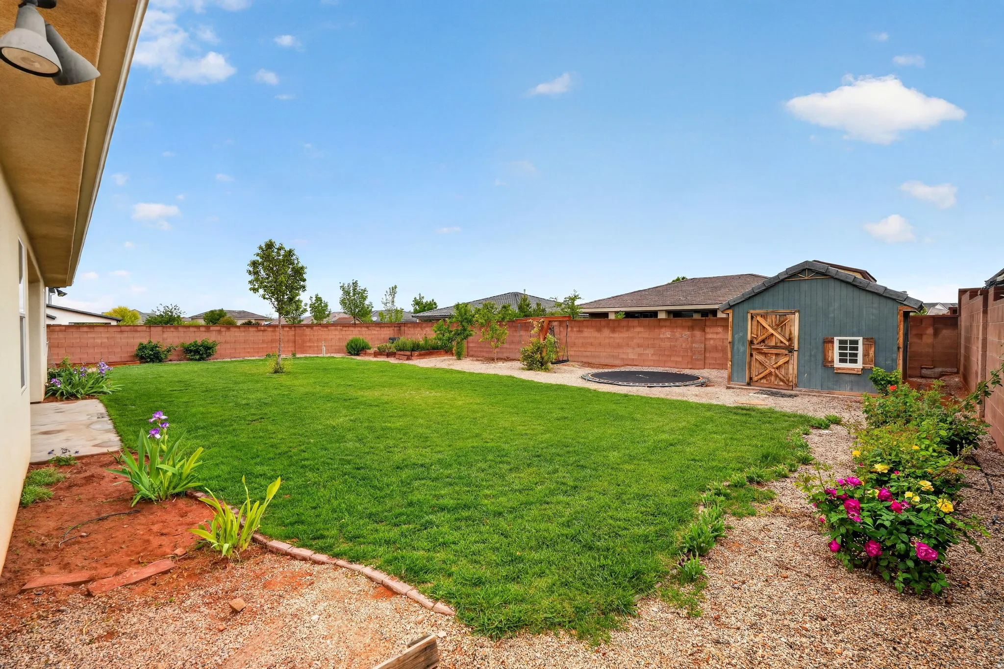 Fenced backyard featuring an outbuilding and a patio area