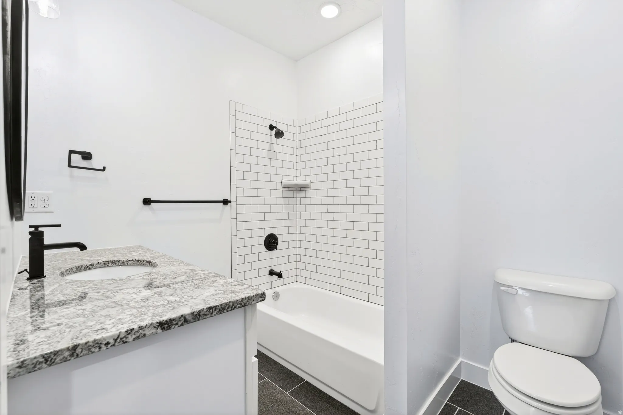 Full bath featuring vanity, dark tile patterned floors, shower / tub combination, and recessed lighting