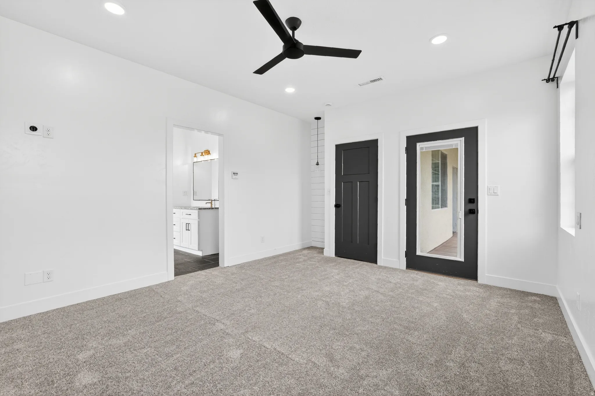 Unfurnished bedroom with dark carpet, a ceiling fan, recessed lighting, and ensuite bath