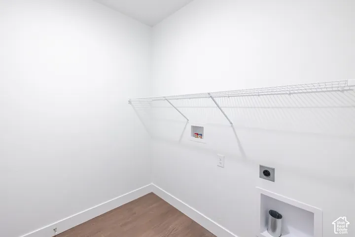 Wood-finish flooring with white baseboards, white walls, and wire shelving