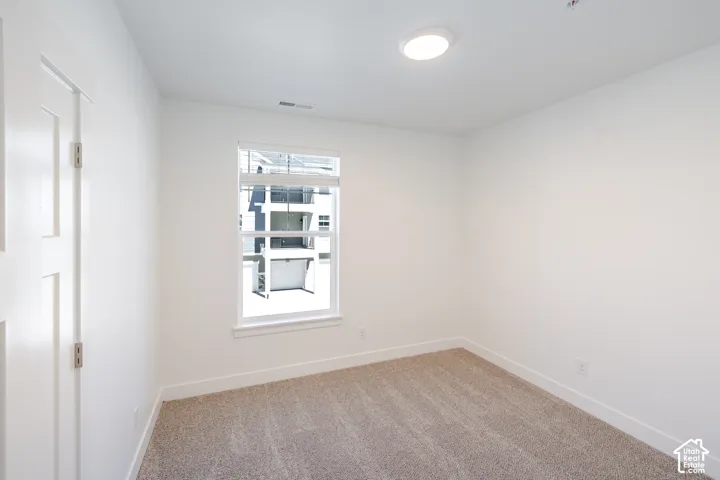 Neutral wall finishes, recessed ceiling light, window with horizontal blinds, neutral carpet, and white trim