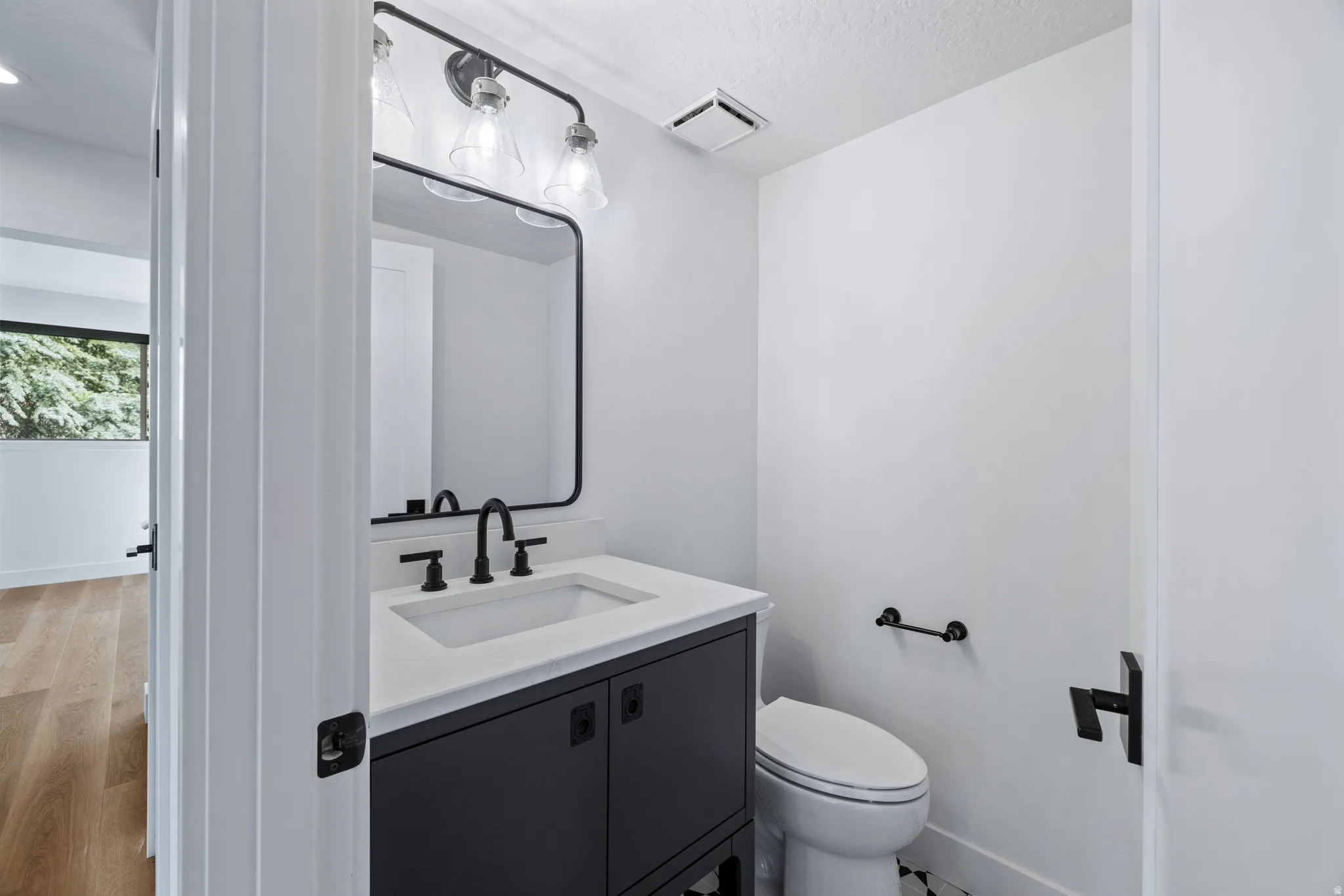 Half bath featuring vanity and light wood-type flooring
