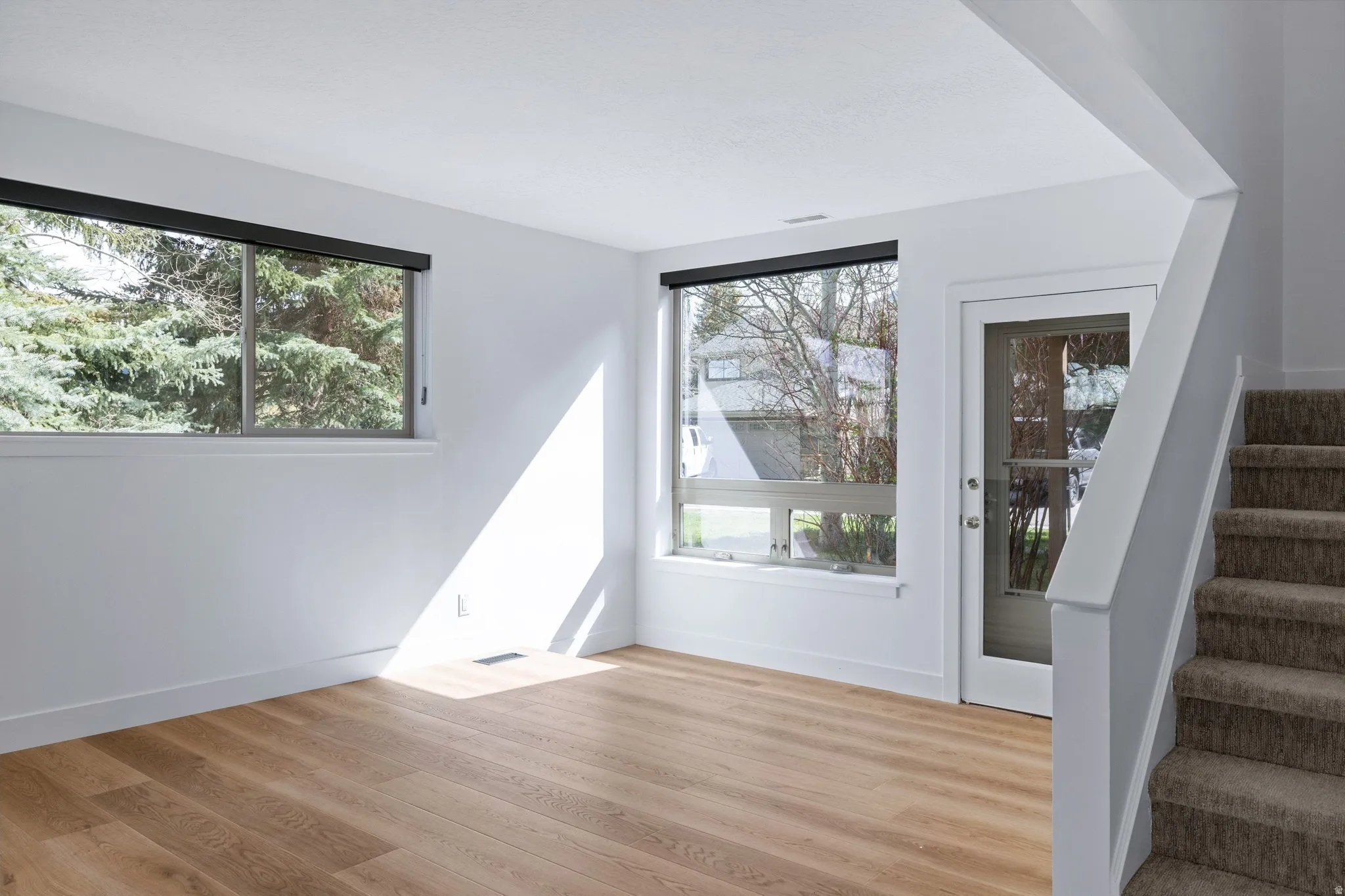 Empty room featuring stairway and light wood-type flooring