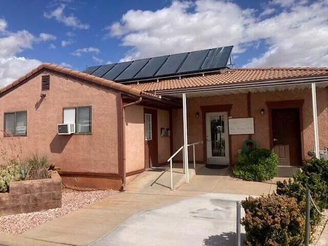 View of front of home featuring solar panels, stucco siding, and a tiled roof