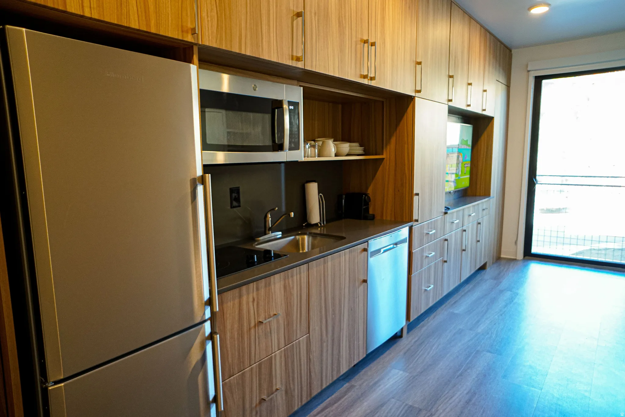 Kitchen with stainless steel appliances, dark wood finished floors, open shelves, modern cabinets, and light wood finish cabinets