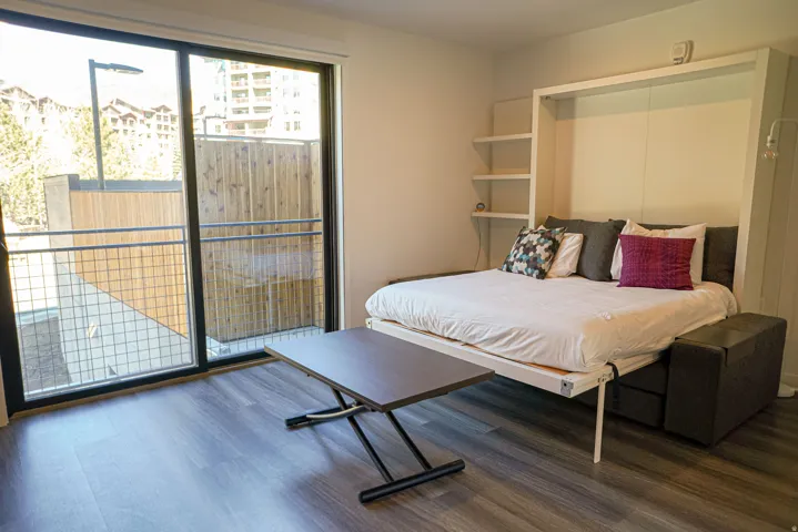 Bedroom featuring access to exterior and dark wood-style flooring