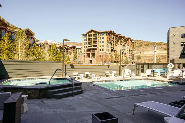 Community pool with a hot tub and a patio area