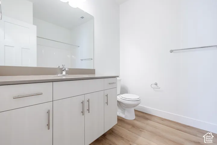 White vanity with brushed nickel hardware, neutral countertop, and integrated sink
