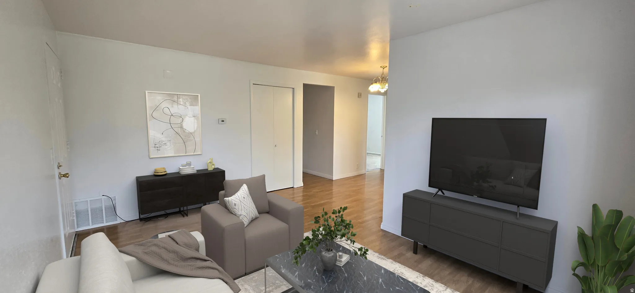 Living room with wood finished floors and a chandelier
