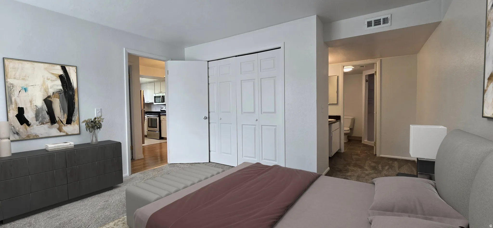 Bedroom featuring a closet, dark colored carpet, and connected bathroom