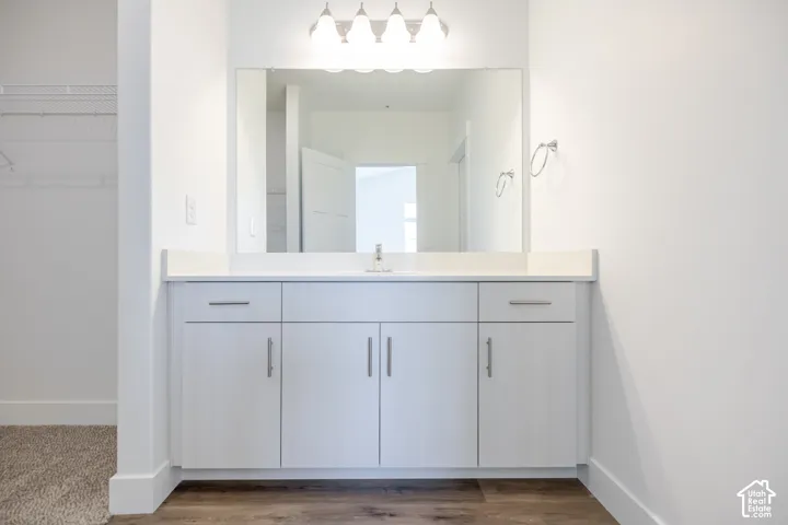 White vanity with an integrated sink, polished chrome faucet, and expansive mirror