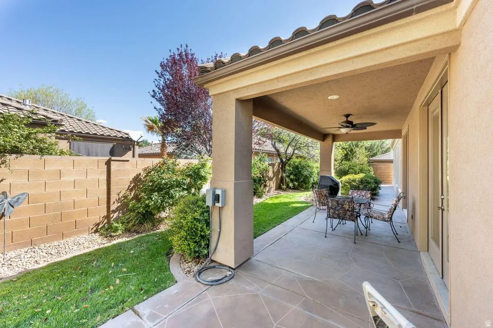Fenced backyard featuring ceiling fan, outdoor dining area, and a patio area
