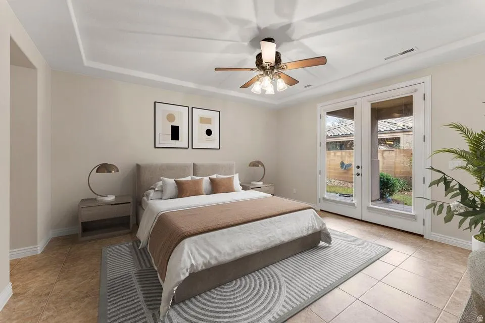 Bedroom with french doors, access to exterior, a ceiling fan, a raised ceiling, and light tile patterned floors