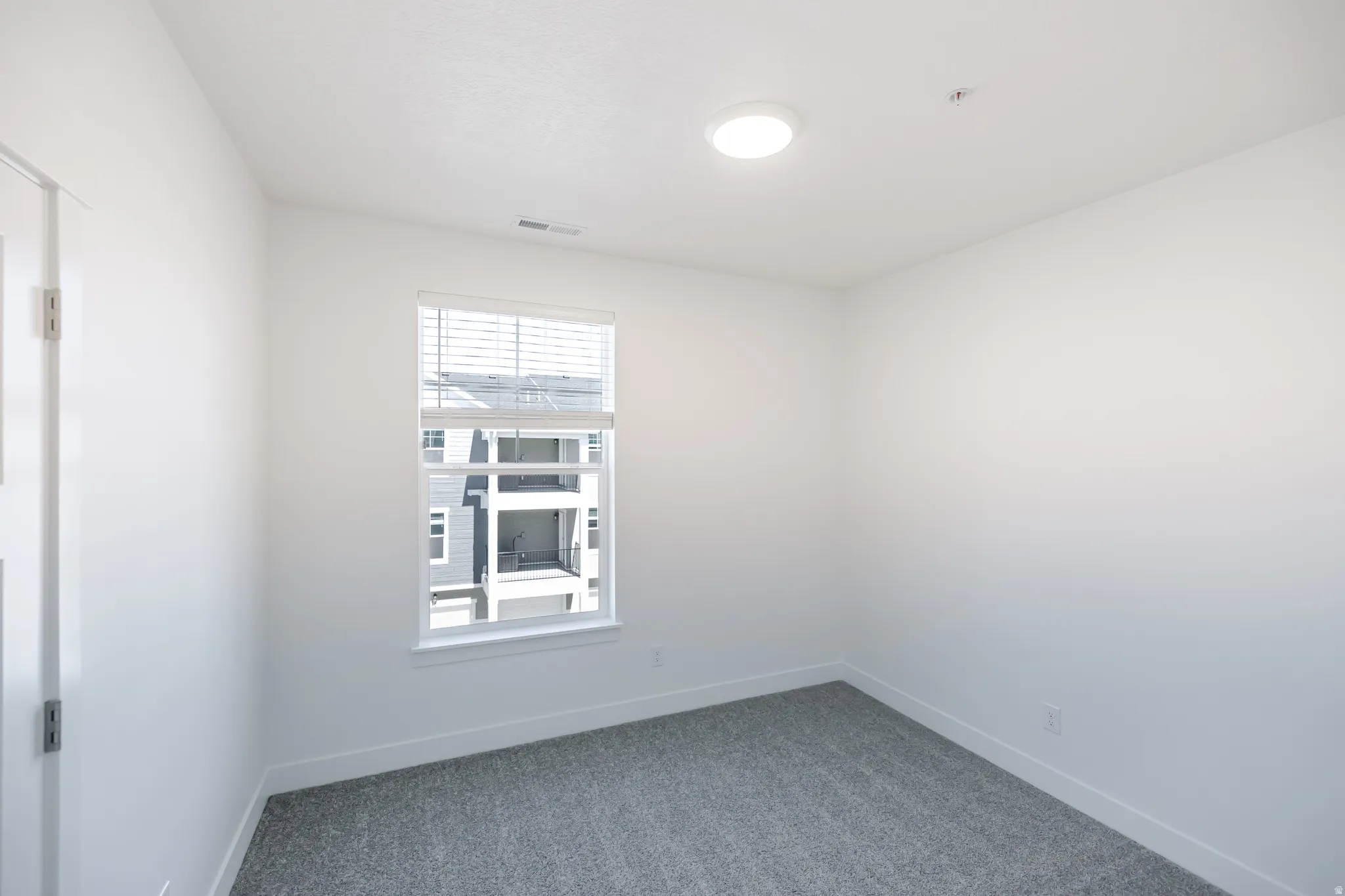 Neutral wall finishes with a window featuring blinds