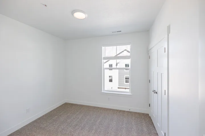 Recessed ceiling light, neutral carpet, white walls, double-door closet, and white window blinds