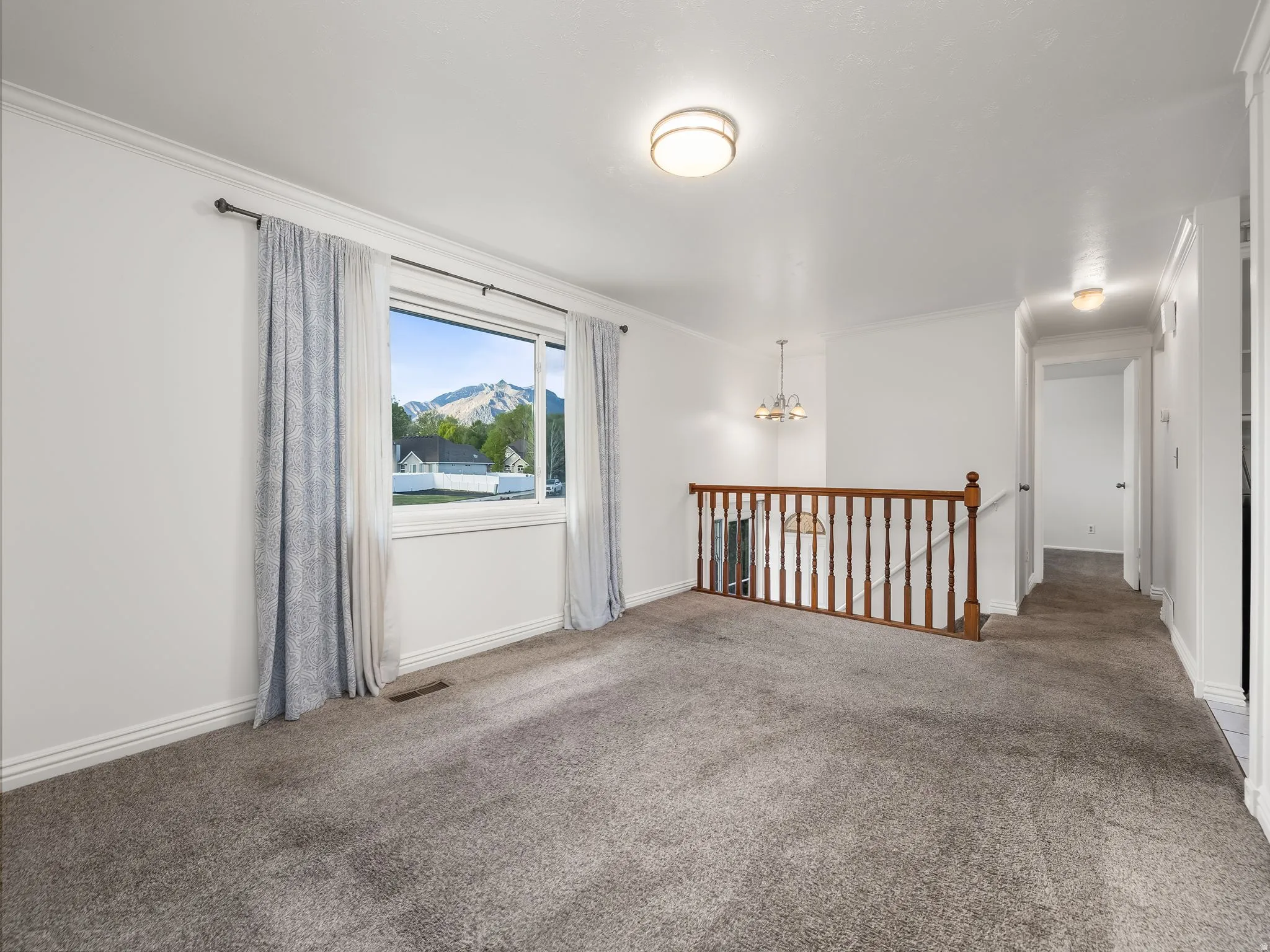 Carpeted living room with a mountain view and crown molding