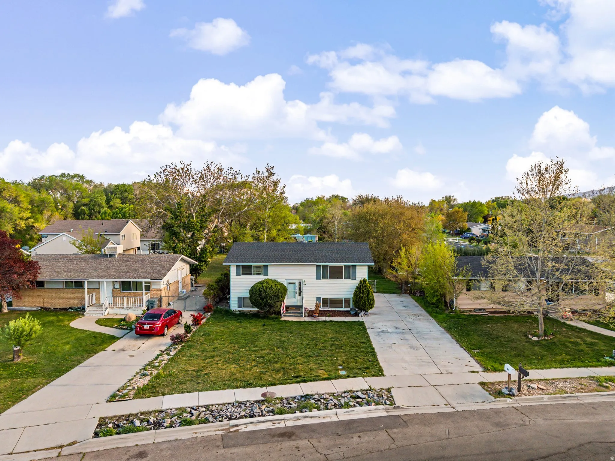 Split foyer home featuring concrete driveway and a residential view