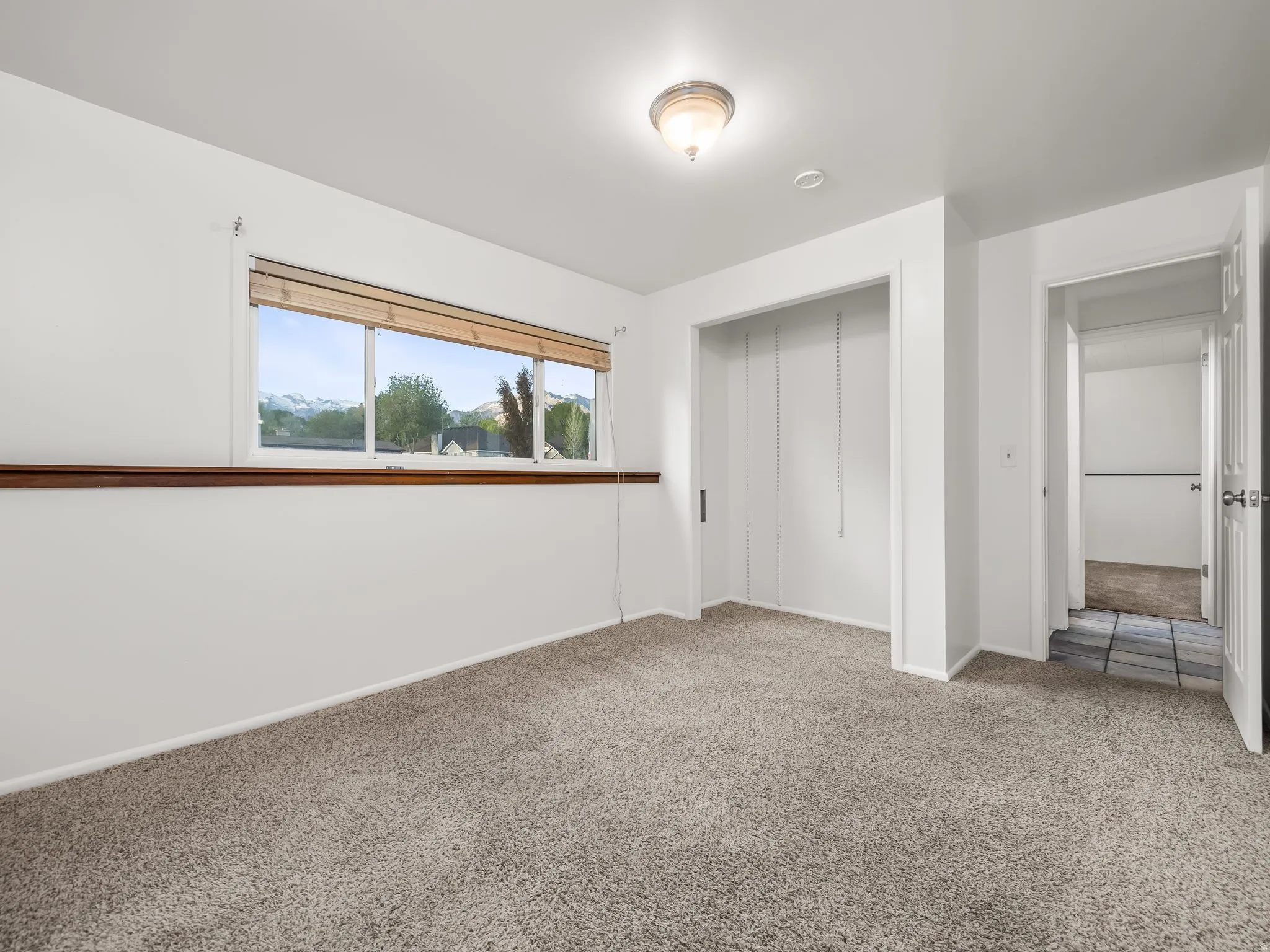 Unfurnished bedroom with light colored carpet and a closet