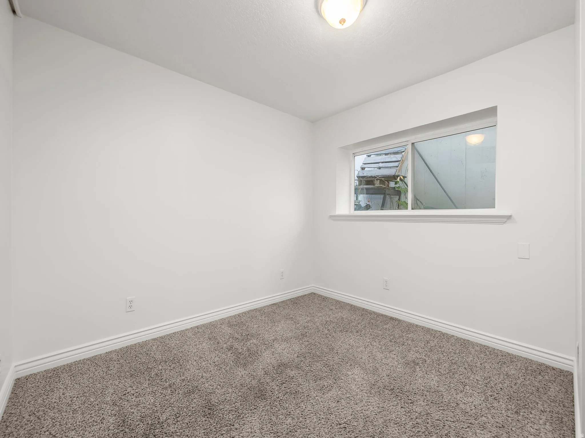 Empty room with carpet and baseboards