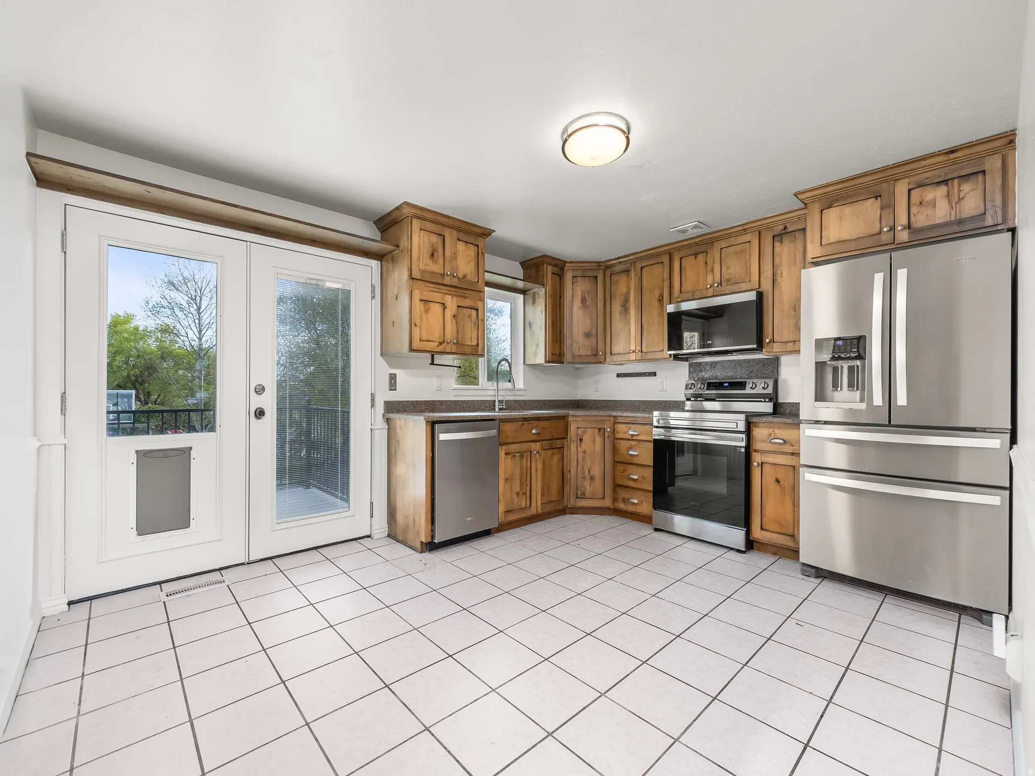 Eat in Kitchen featuring stainless steel appliances, wood finish cabinetry, and light tile patterned floors