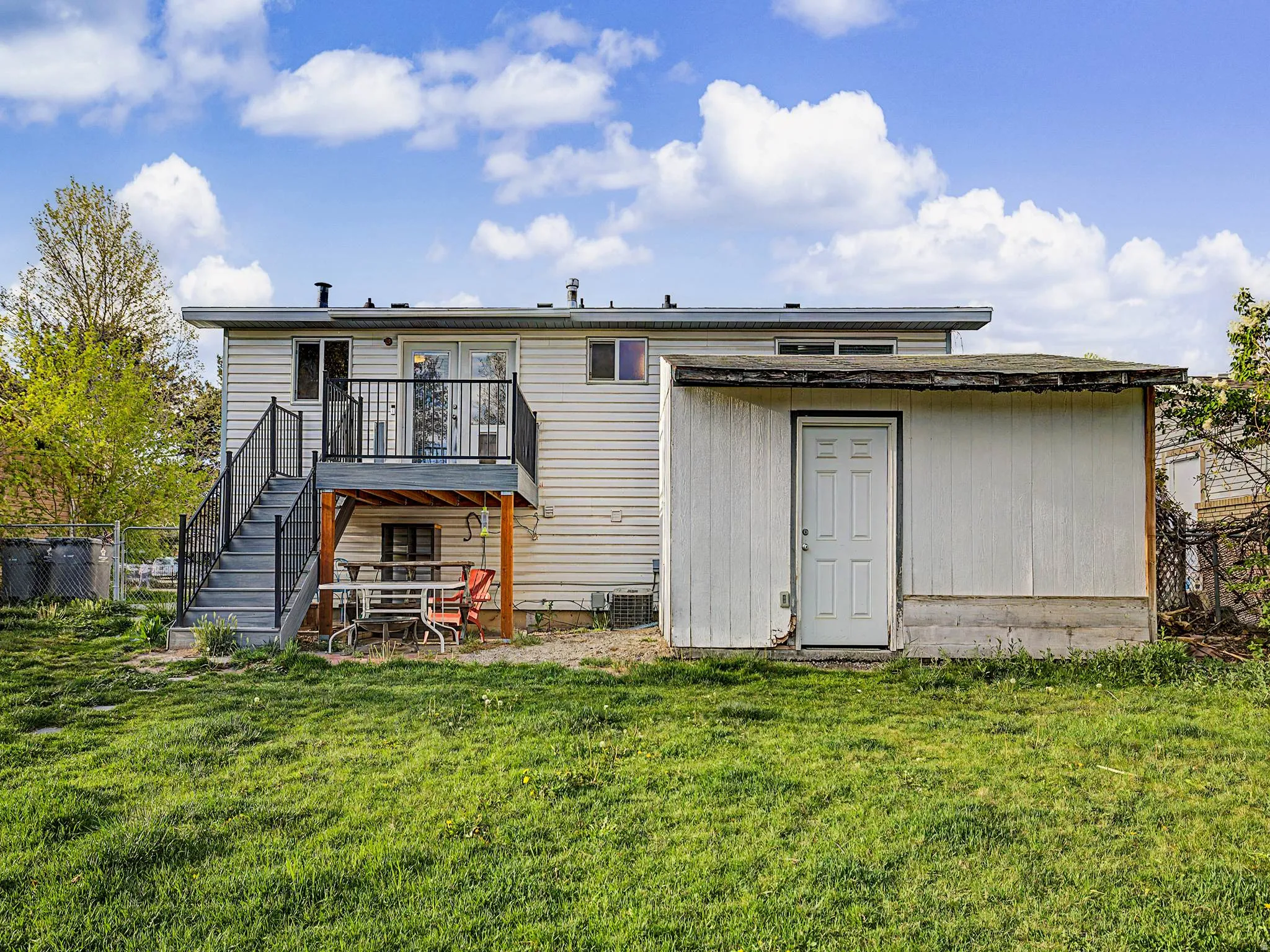 Back of property with a shed and a wooden deck