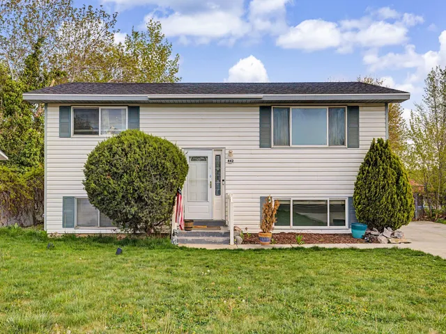 Split-level home featuring a front yard and entry steps