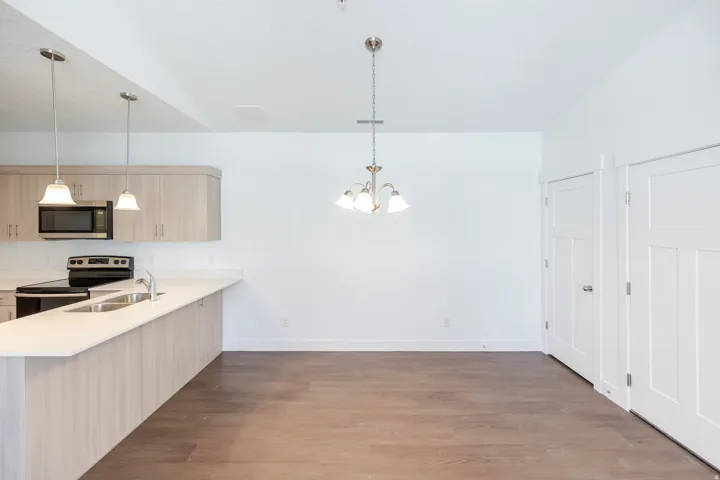Kitchen featuring light wood-finish cabinetry, stainless steel sink, and light-toned countertops