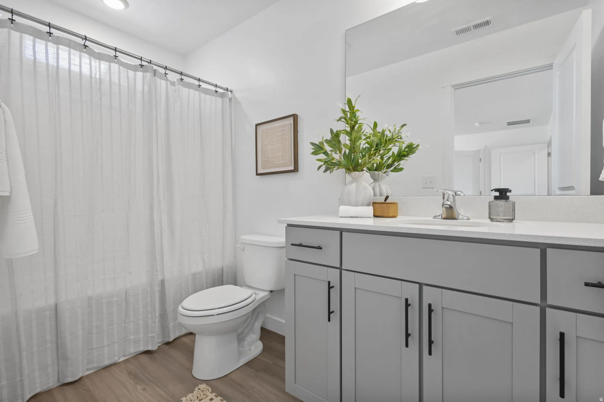 Full bathroom featuring vanity, light wood-style floors, and shower / tub combo with curtain