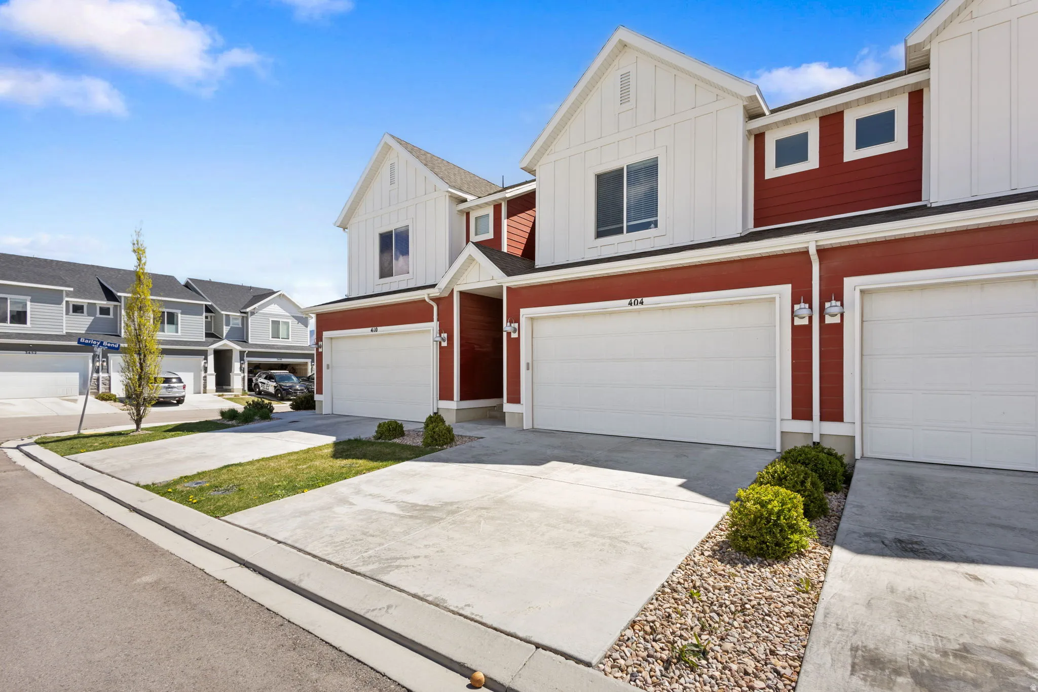 View of front of home with board and batten siding, a residential view, a garage, and driveway