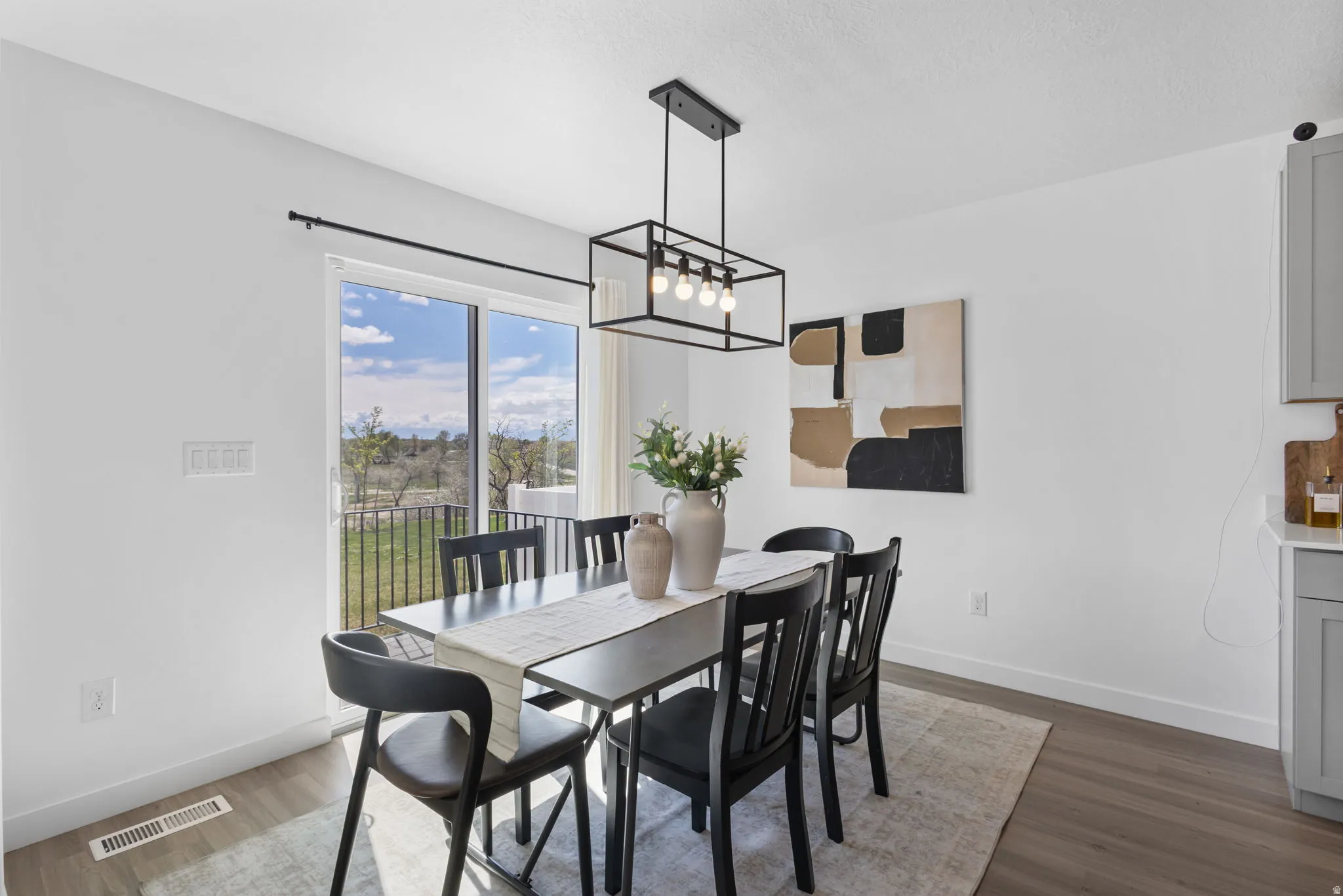 Dining space with dark wood-style floors and a chandelier
