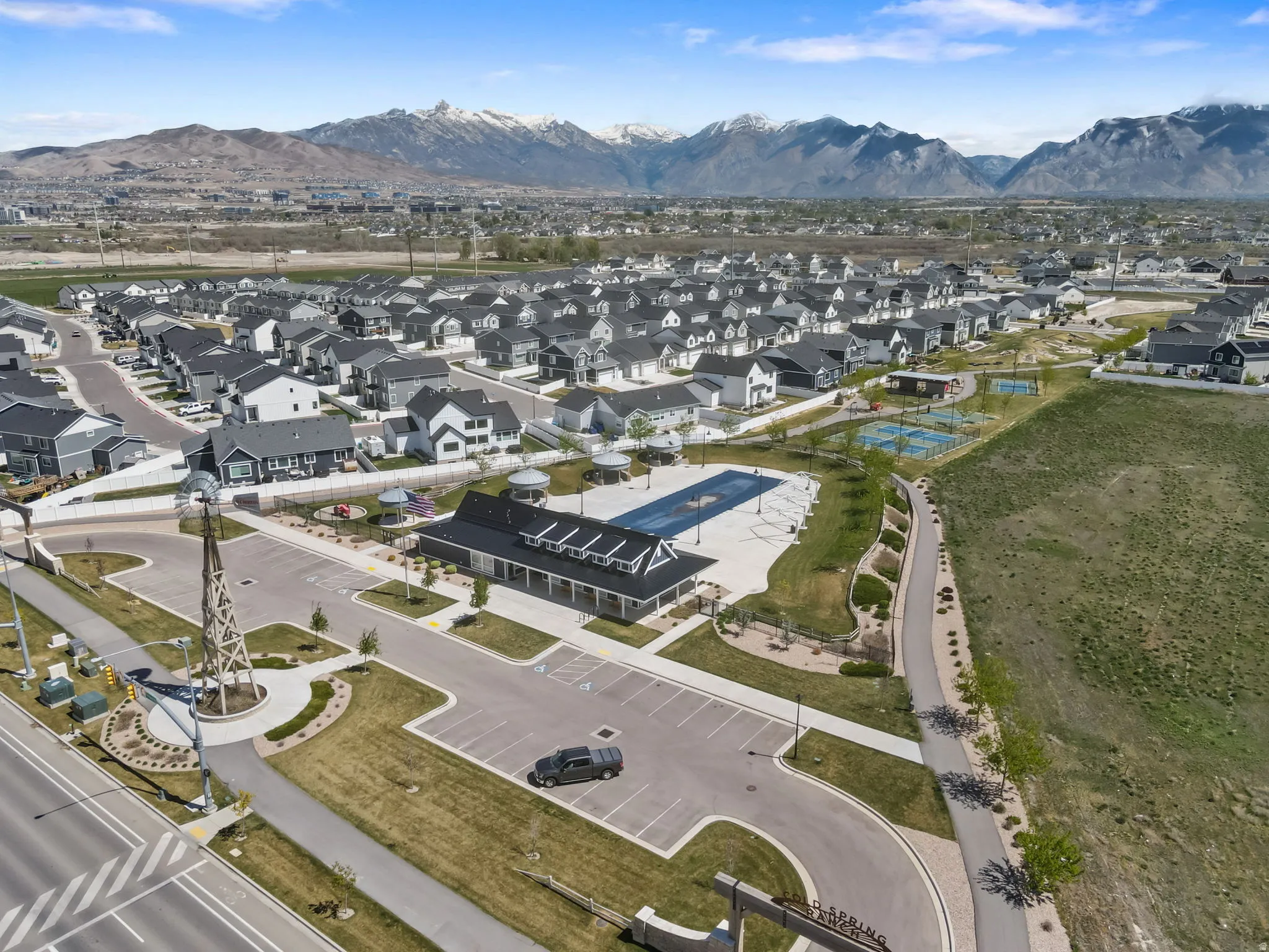 Aerial view of property and surrounding area featuring mountains and nearby suburban area