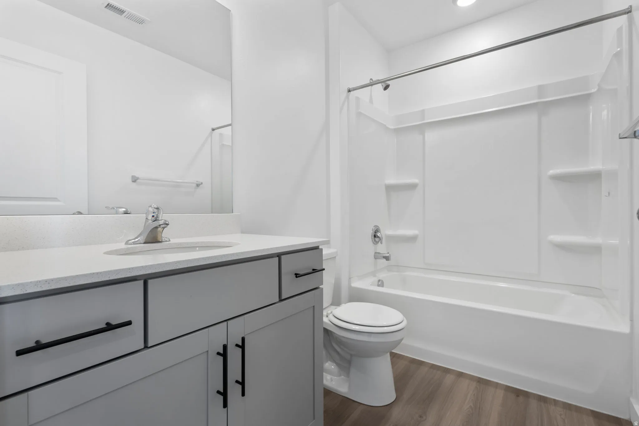 Full bathroom featuring dark wood-style flooring, vanity, and tub / shower combination