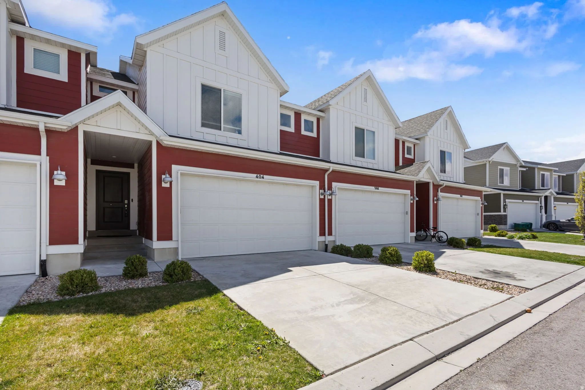 View of front of house featuring board and batten siding, a residential view, concrete driveway, and an attached garage