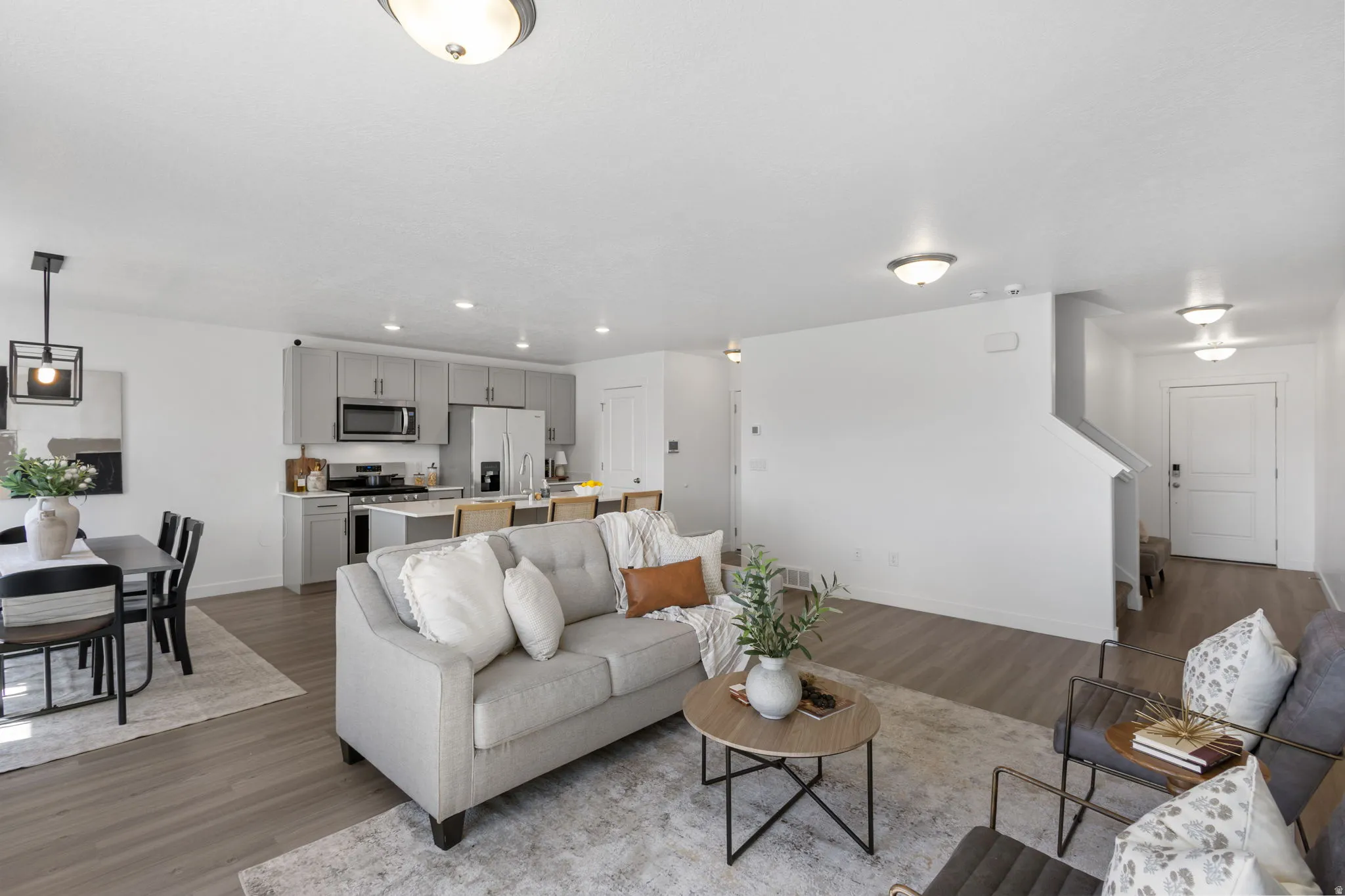 Living room with light wood-style flooring and recessed lighting