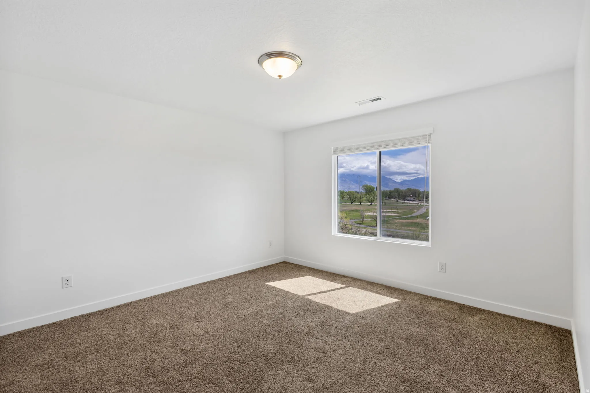 Unfurnished room featuring dark carpet and a mountain view