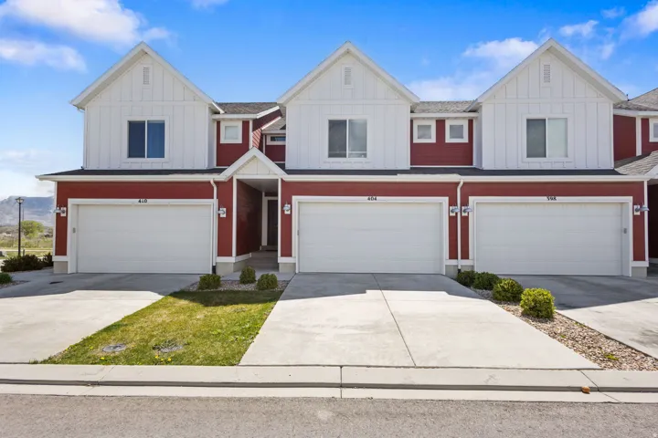 View of front of house with board and batten siding, a garage, and driveway
