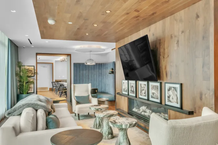 Living room with recessed lighting, wood ceiling, wood walls, a glass covered fireplace, and wood finished floors