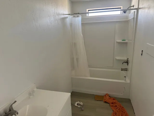 Full bathroom with vanity, wood finished floors, and shower / bathtub combination with curtain