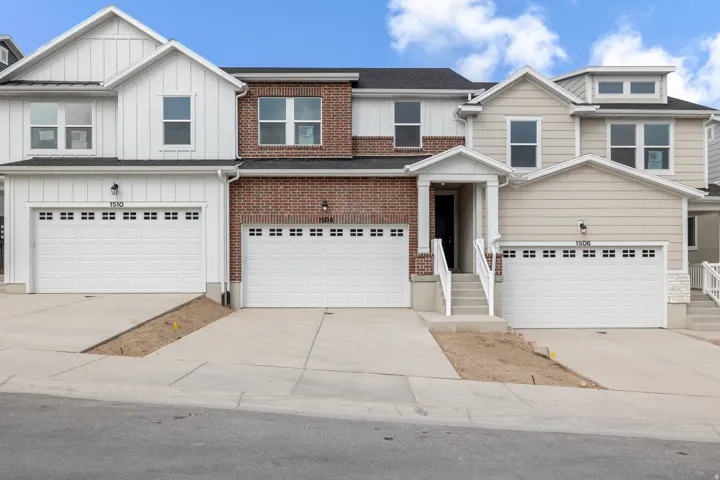 Brick and siding exterior with a covered entry, multiple windows, and two-car garage