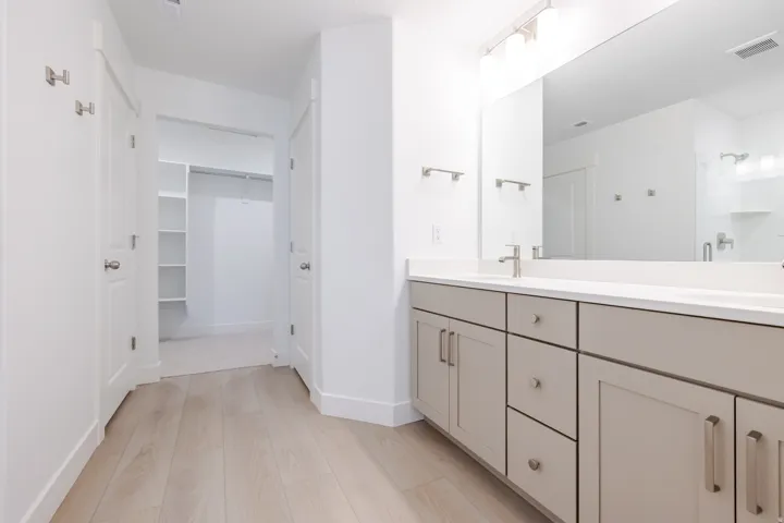 Dual vanity with light gray cabinetry and white countertop