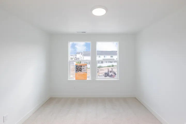 Neutral wall tones, carpeted flooring, and a flush-mount ceiling light