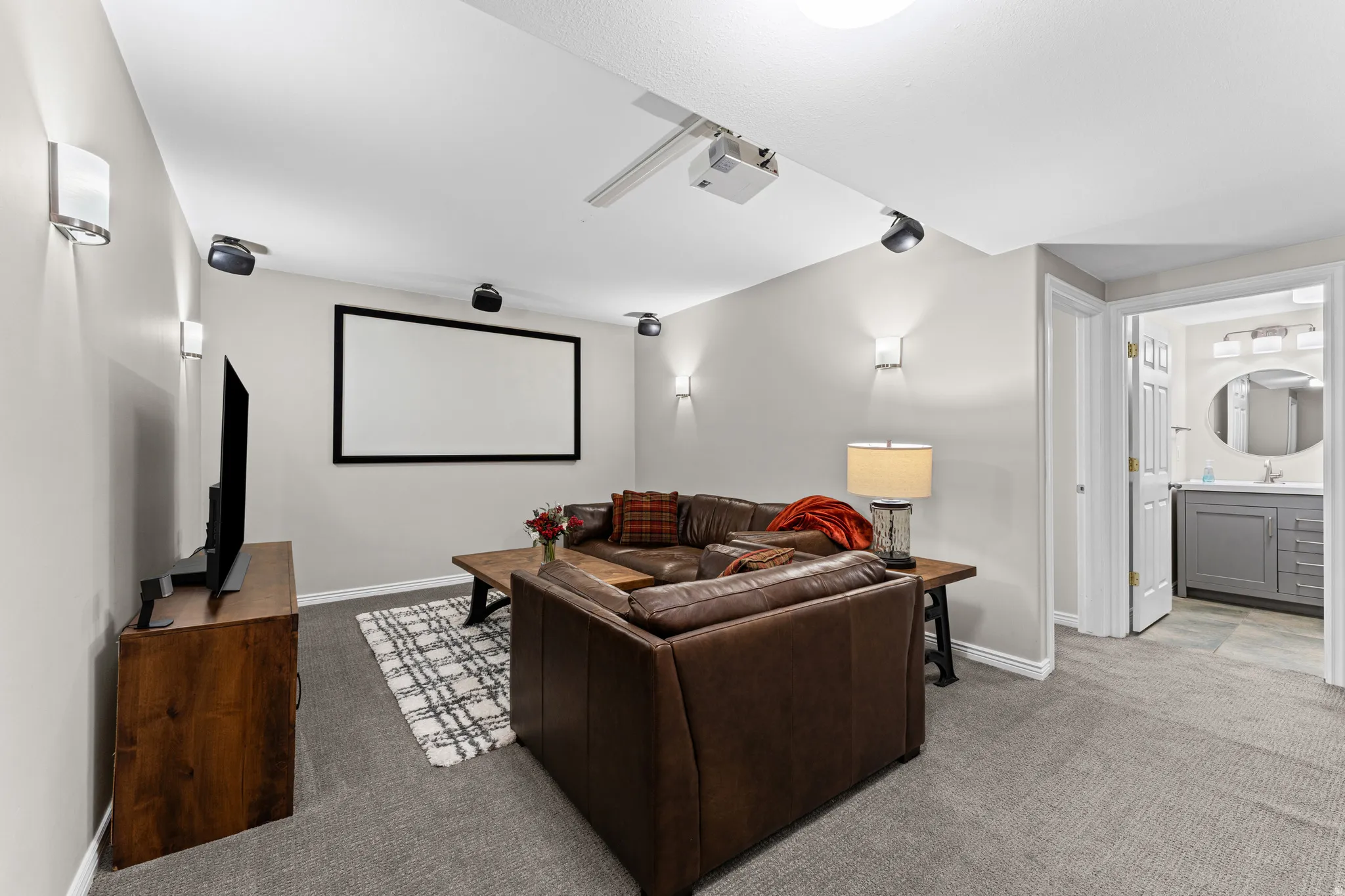 Home theater with light colored carpet and baseboards