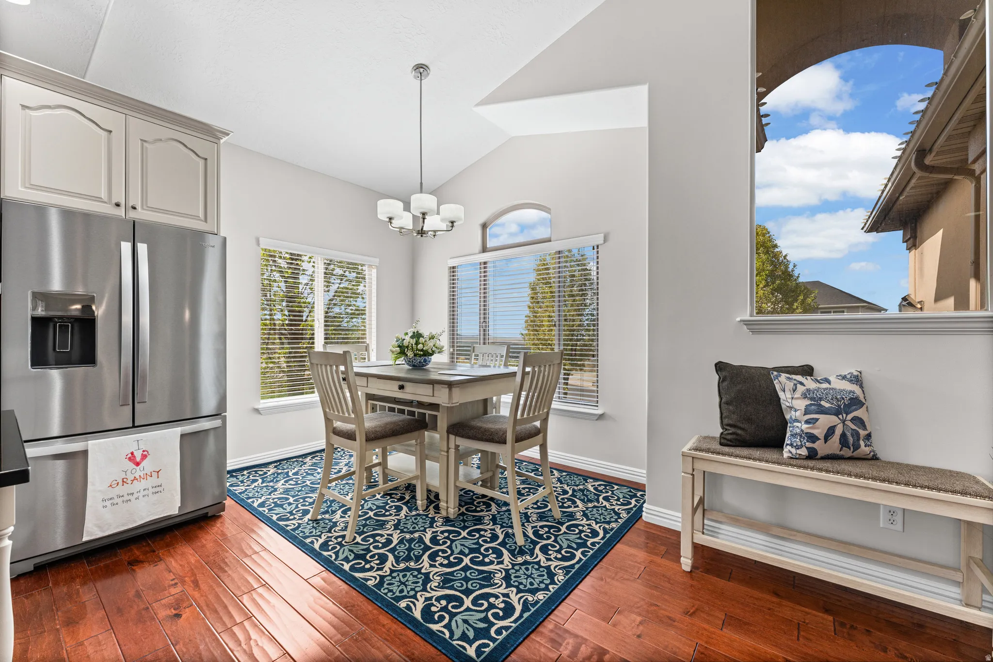 Dining room with vaulted ceiling, dark wood finished floors, and suspended lighting