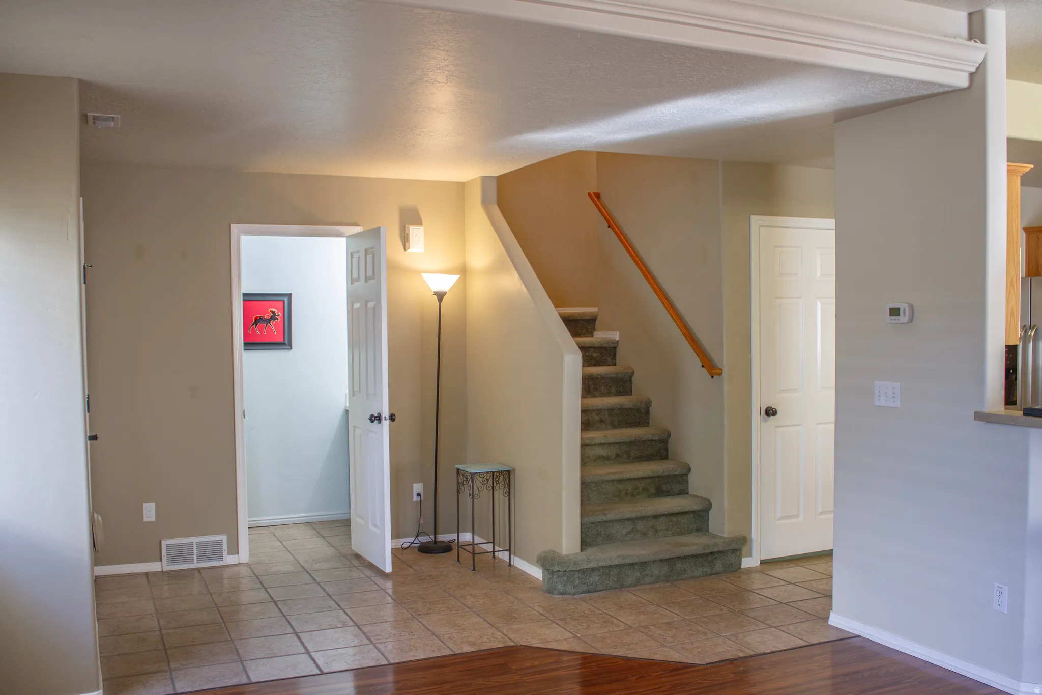 Staircase with tile patterned floors and baseboards