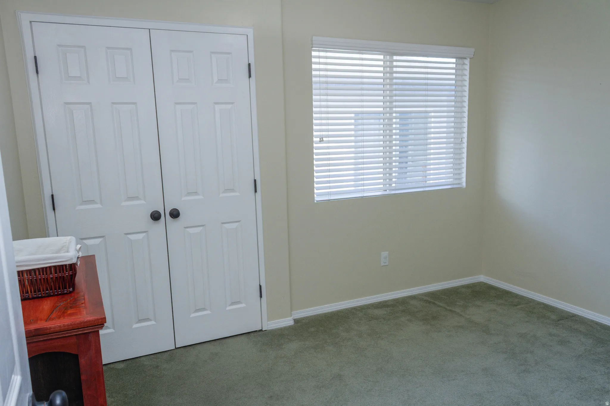 Unfurnished bedroom with light colored carpet and a closet