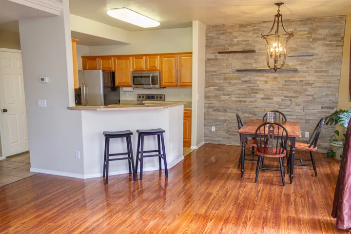 Kitchen featuring suspended lighting, stainless steel appliances, light countertops, a breakfast bar area, and a peninsula