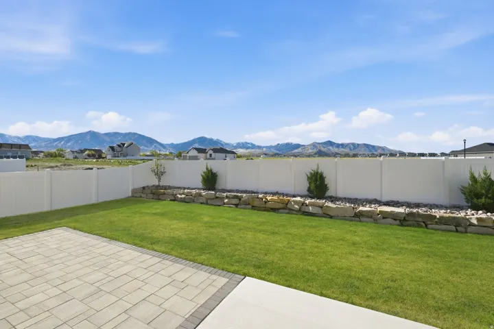 Fenced backyard with a mountain view and a patio area
