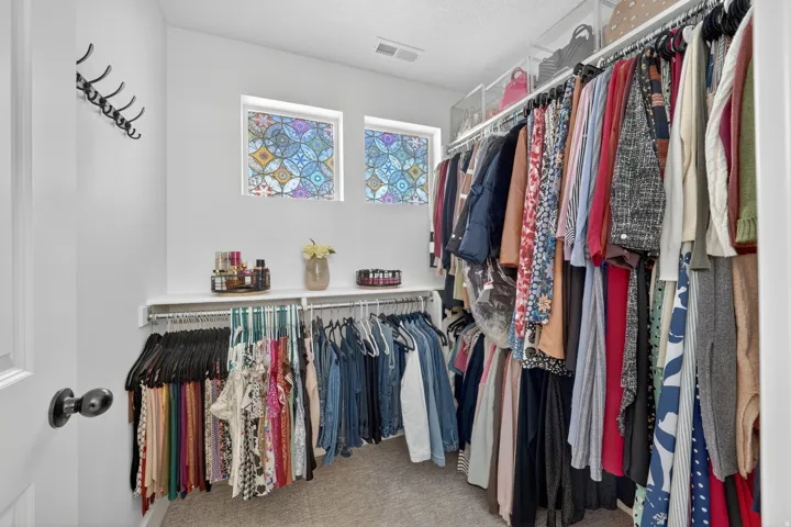 Walk in closet with light carpet